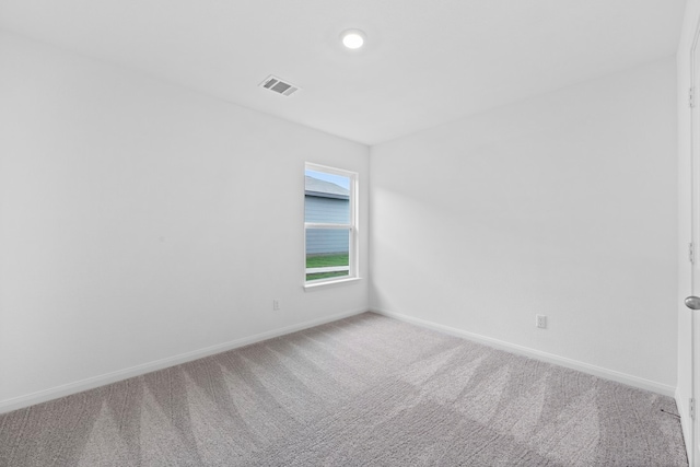 unfurnished room featuring carpet flooring, visible vents, and baseboards