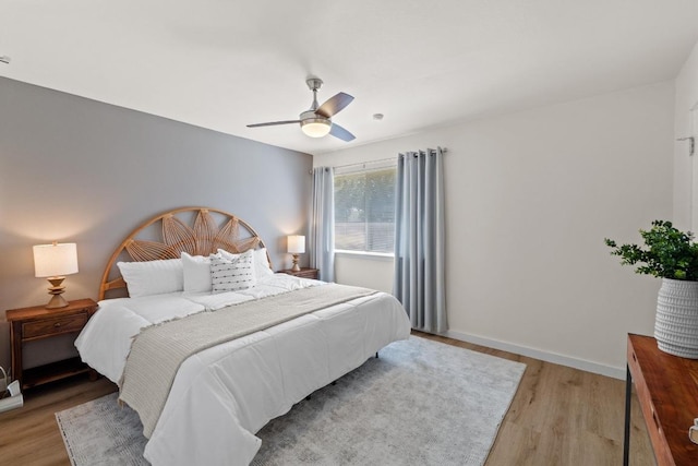 bedroom with baseboards, light wood finished floors, and ceiling fan