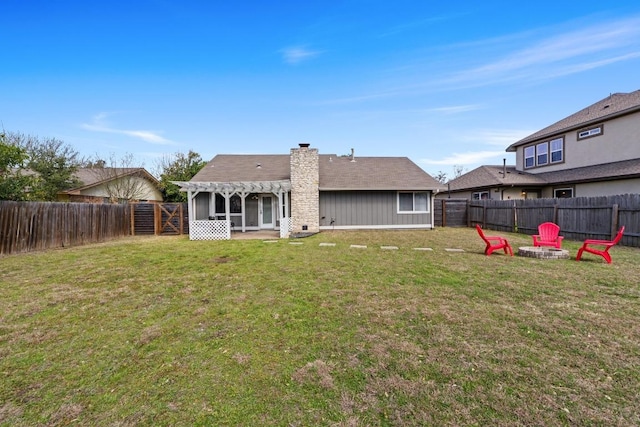 rear view of house with a chimney, a fire pit, a fenced backyard, and a pergola