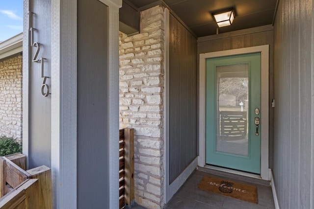 property entrance with stone siding and brick siding