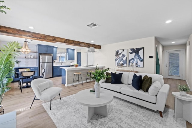 living area featuring beamed ceiling, recessed lighting, visible vents, and light wood-style flooring