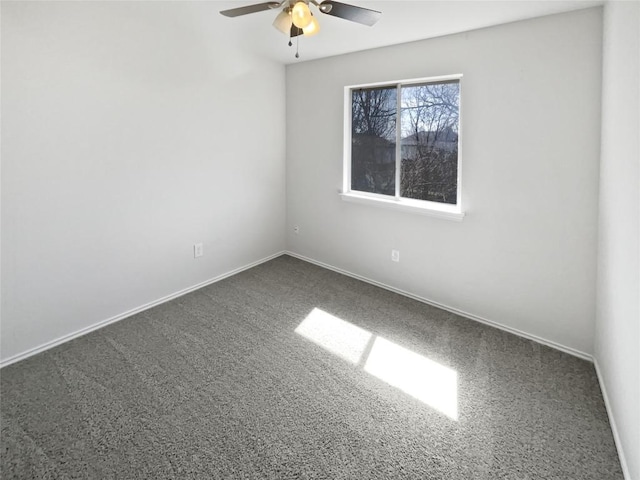 unfurnished room with ceiling fan, baseboards, and dark colored carpet