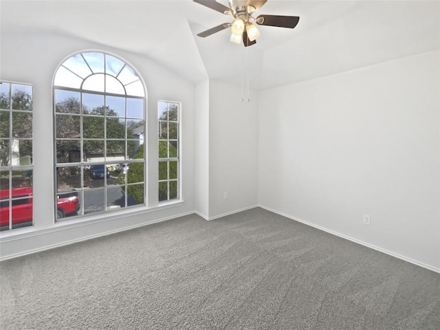 empty room with lofted ceiling, baseboards, dark colored carpet, and ceiling fan