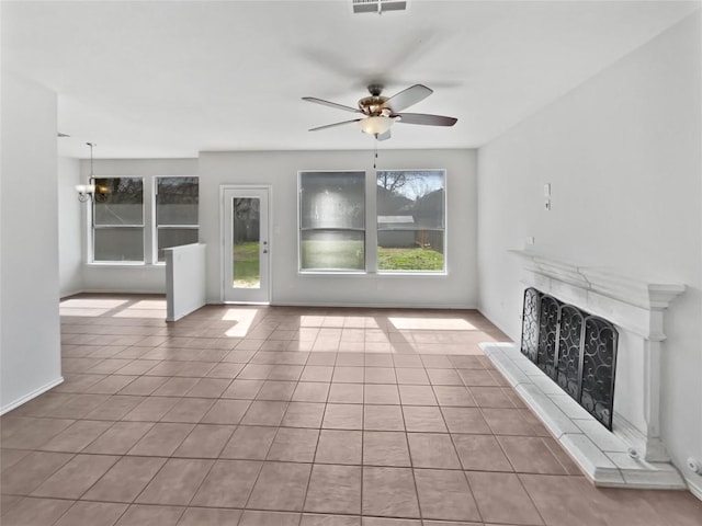 unfurnished living room featuring tile patterned flooring, ceiling fan with notable chandelier, visible vents, and a high end fireplace