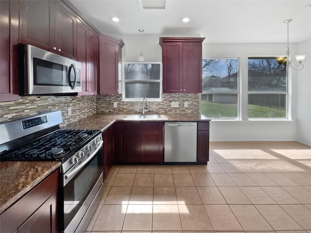 kitchen with a sink, tasteful backsplash, appliances with stainless steel finishes, and dark brown cabinets