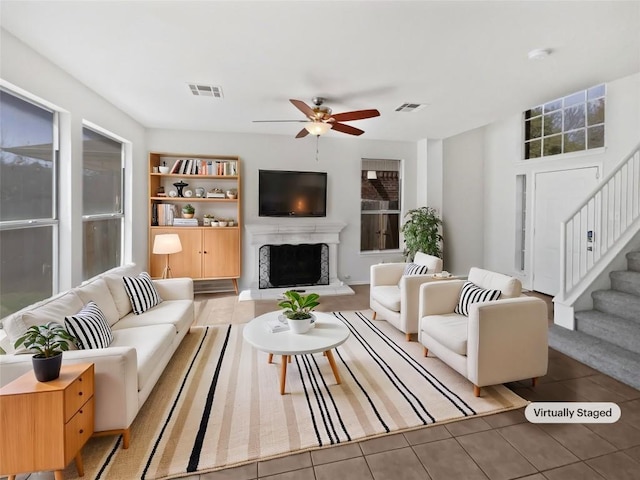 13449 Gent Dr, Austin, TX 78729 - living area featuring stairway, ceiling fan, a fireplace with raised hearth, tile patterned flooring, and built in features