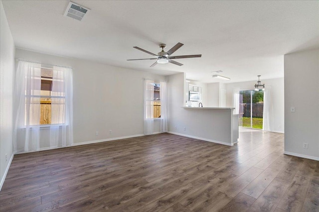 304 Watergate Way, Hutto, TX 78634 - empty room featuring ceiling fan with notable chandelier, visible vents, dark wood-style flooring, and baseboards