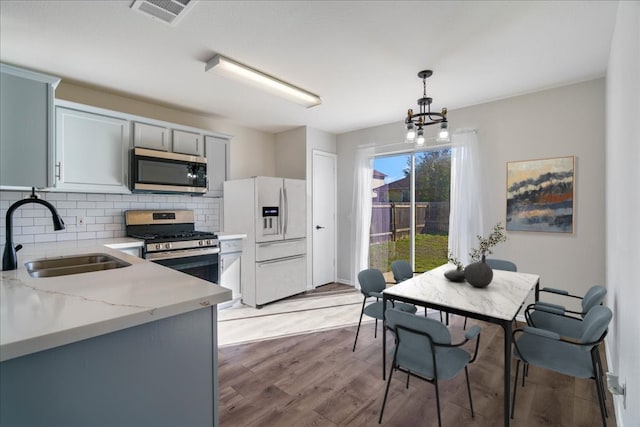 304 Watergate Way, Hutto, TX 78634 - kitchen featuring visible vents, a sink, decorative backsplash, stainless steel appliances, and light wood-type flooring