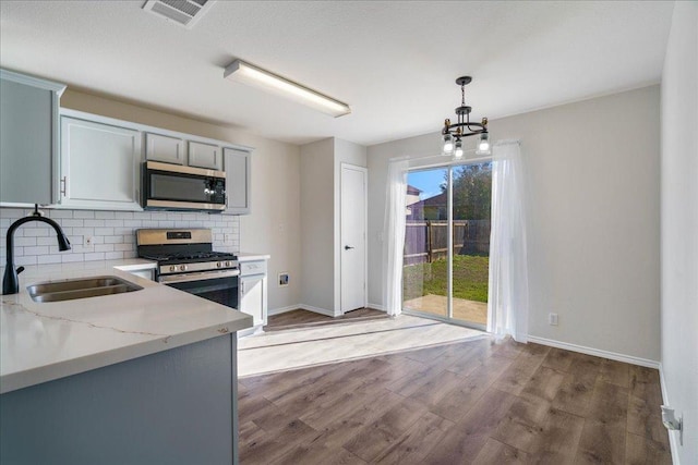 304 Watergate Way, Hutto, TX 78634 - kitchen featuring visible vents, decorative backsplash, wood finished floors, stainless steel appliances, and a sink