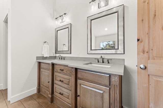 full bathroom featuring double vanity, tile patterned floors, baseboards, and a sink