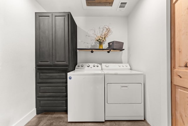 clothes washing area featuring washing machine and dryer, cabinet space, baseboards, and visible vents