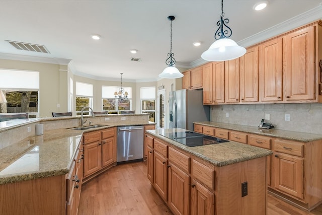 kitchen featuring visible vents, ornamental molding, a sink, appliances with stainless steel finishes, and a large island with sink