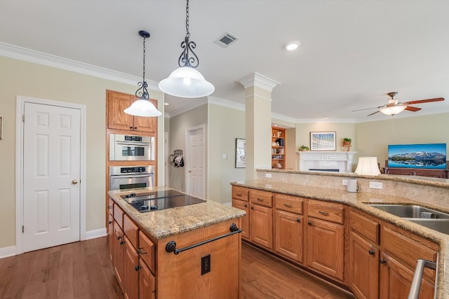 kitchen with wood finished floors, black electric stovetop, light stone countertops, and open floor plan