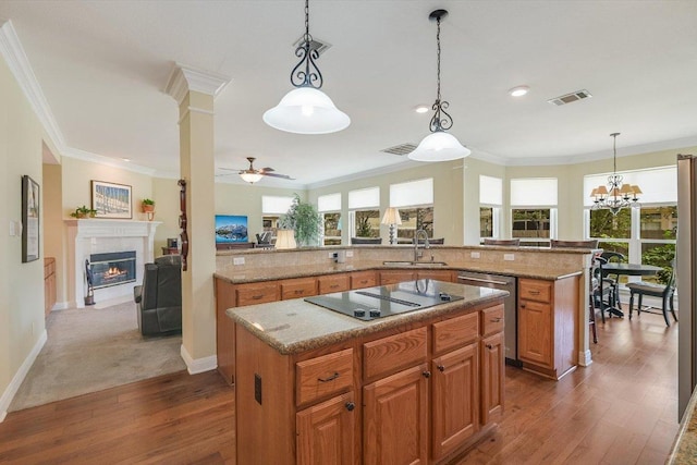 kitchen featuring ornamental molding, a sink, a kitchen island, stainless steel dishwasher, and black electric cooktop