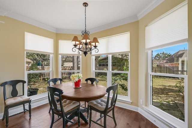 dining space featuring plenty of natural light, an inviting chandelier, dark wood-style flooring, and crown molding