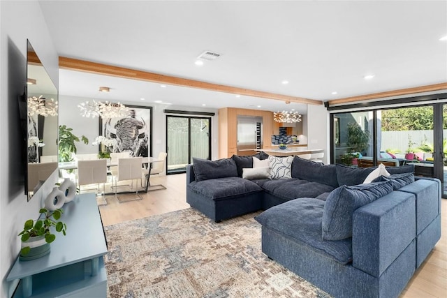 living room with recessed lighting, visible vents, wood finished floors, and a chandelier