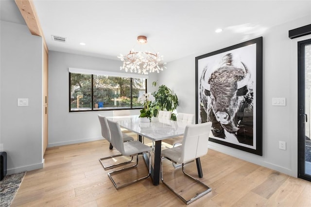 dining room with visible vents, baseboards, a notable chandelier, and light wood finished floors