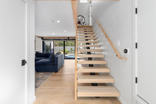 stairs featuring recessed lighting, visible vents, and wood finished floors