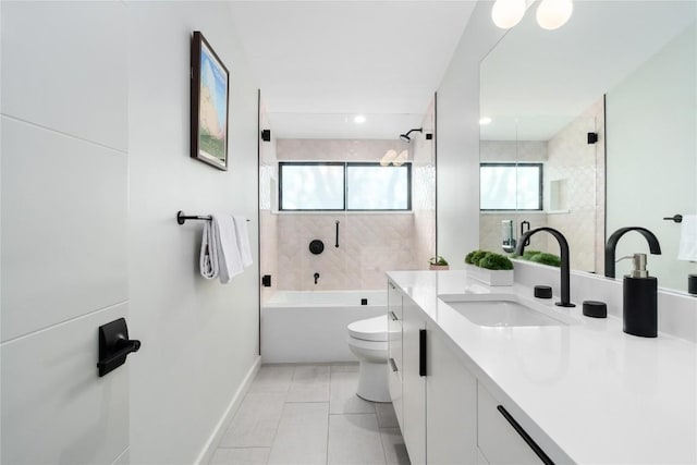 bathroom featuring tile patterned floors, toilet, washtub / shower combination, baseboards, and vanity