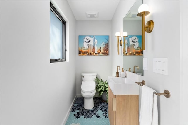 bathroom with visible vents, toilet, vanity, and baseboards