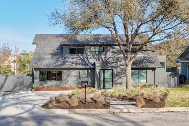 view of front of house featuring fence and a shingled roof