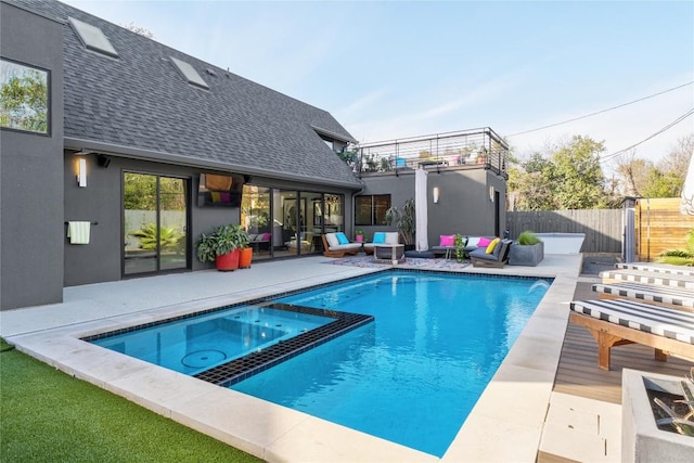 view of pool featuring a patio area, an outdoor hangout area, a pool with connected hot tub, and fence