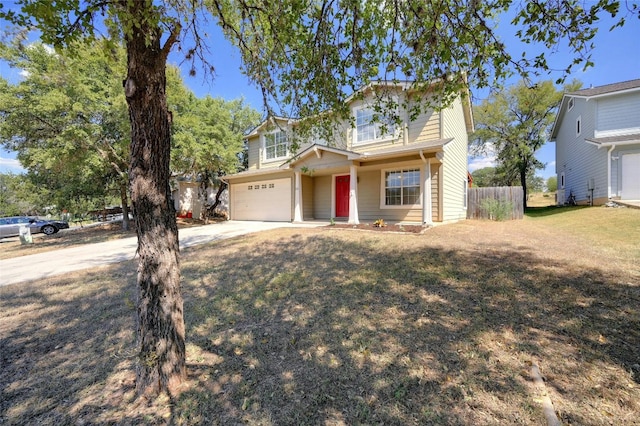 traditional-style home with a front lawn, an attached garage, fence, and driveway