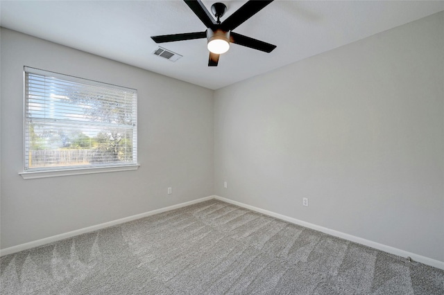 unfurnished room with visible vents, baseboards, carpet, and a ceiling fan