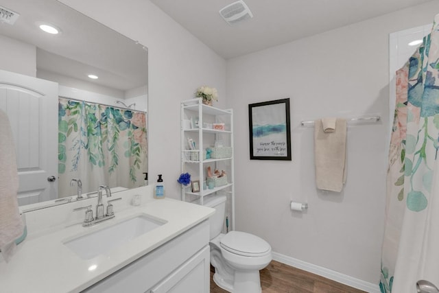 full bathroom featuring vanity, wood finished floors, visible vents, baseboards, and toilet