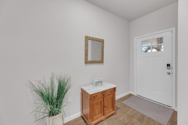 entryway with light wood-style flooring and baseboards