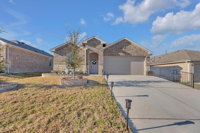 view of front of house with a garage, brick siding, driveway, and fence