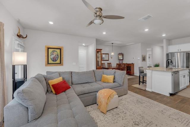 living room featuring recessed lighting, visible vents, ceiling fan, and light wood finished floors