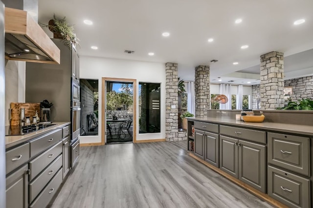 kitchen with premium range hood, decorative columns, oven, gray cabinetry, and black electric cooktop