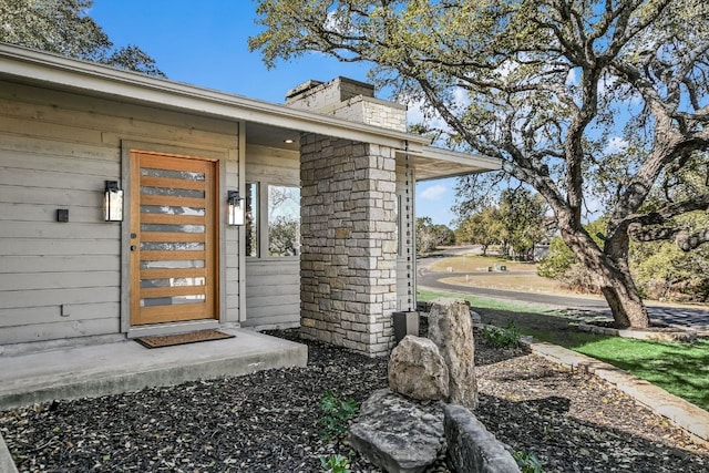 doorway to property with a chimney