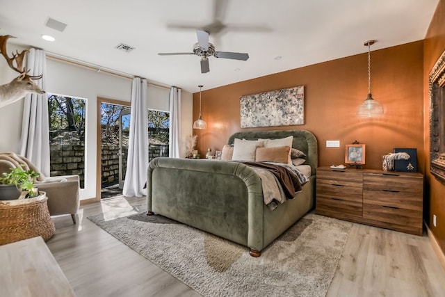 bedroom featuring access to exterior, visible vents, a ceiling fan, and light wood-style floors