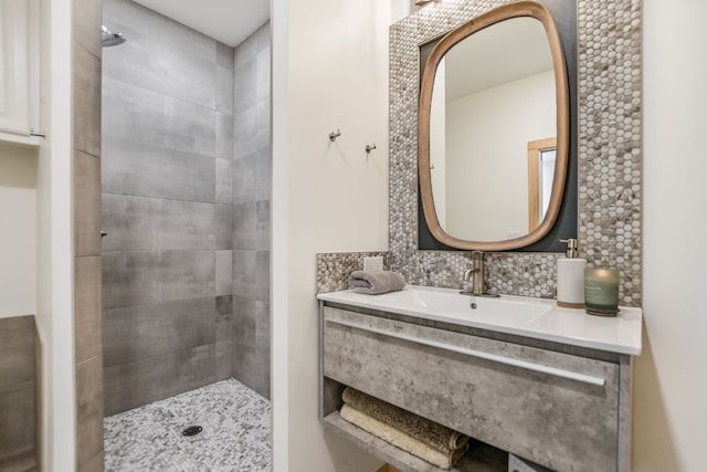 full bathroom featuring tasteful backsplash, tiled shower, and vanity