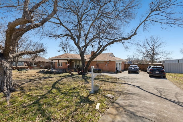 single story home featuring fence, brick siding, driveway, and a chimney