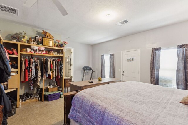 carpeted bedroom with visible vents, a closet, and ceiling fan