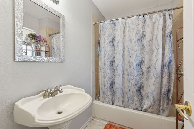 bathroom with shower / tub combo with curtain and a sink