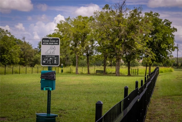 view of property's community featuring a yard and fence