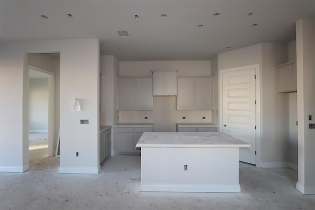 kitchen featuring a center island, concrete floors, and baseboards