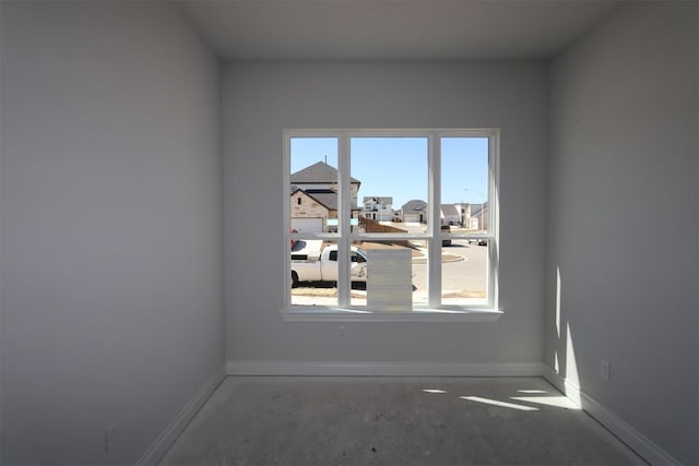 empty room with a healthy amount of sunlight and baseboards