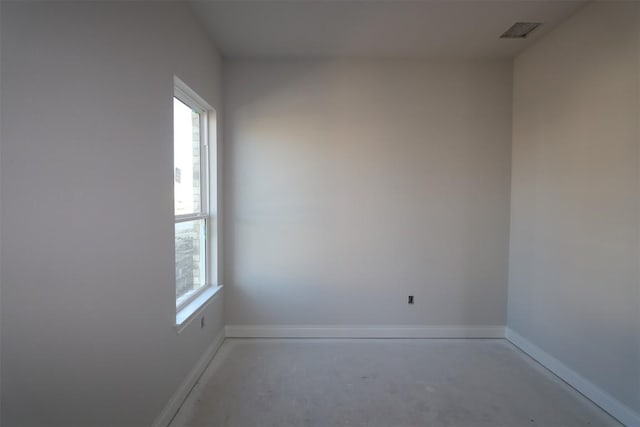 spare room with visible vents, concrete flooring, and baseboards