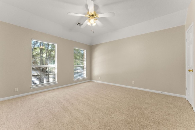 carpeted empty room featuring visible vents, baseboards, a ceiling fan, and vaulted ceiling