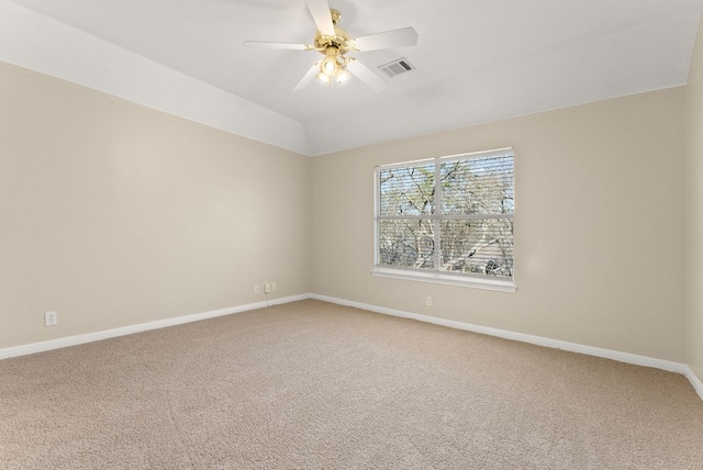 carpeted empty room featuring a ceiling fan, lofted ceiling, baseboards, and visible vents