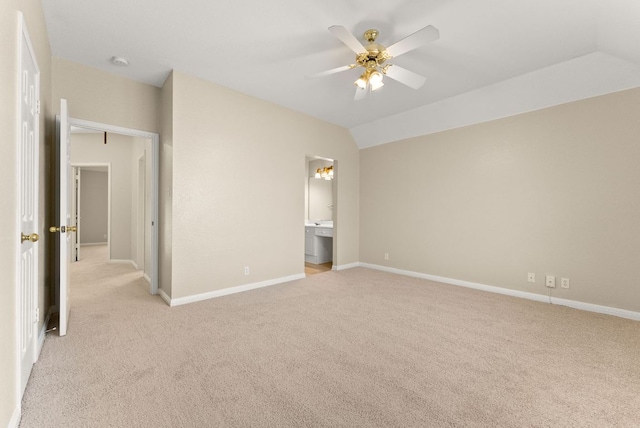 unfurnished bedroom featuring light carpet, baseboards, and lofted ceiling