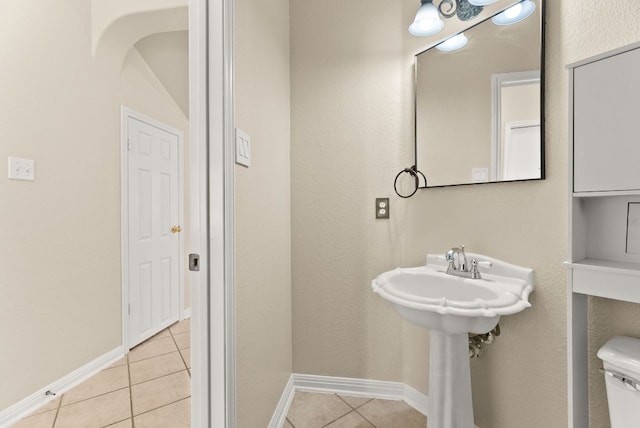 bathroom with tile patterned floors, baseboards, and toilet