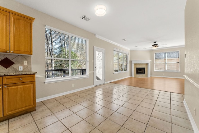 3405 Mulberry Creek Dr, Austin, TX 78732 - unfurnished living room with a ceiling fan, light tile patterned flooring, a fireplace, and ornamental molding