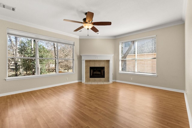 3405 Mulberry Creek Dr, Austin, TX 78732 - unfurnished living room with wood finished floors, a ceiling fan, a tile fireplace, ornamental molding, and baseboards
