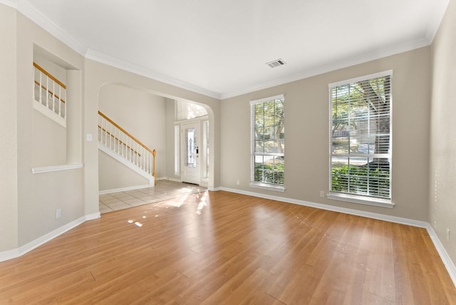 foyer with stairway, baseboards, wood finished floors, and crown molding